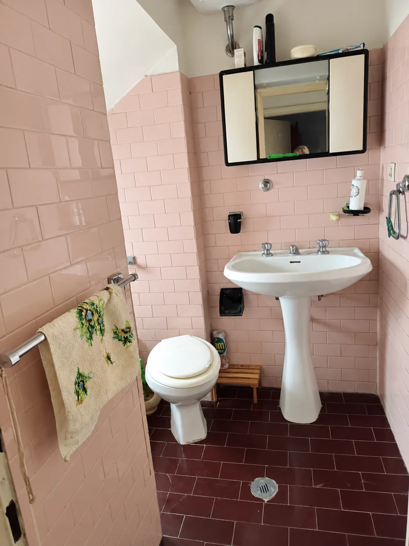 Bagno con sanitari e rivestimento rosa