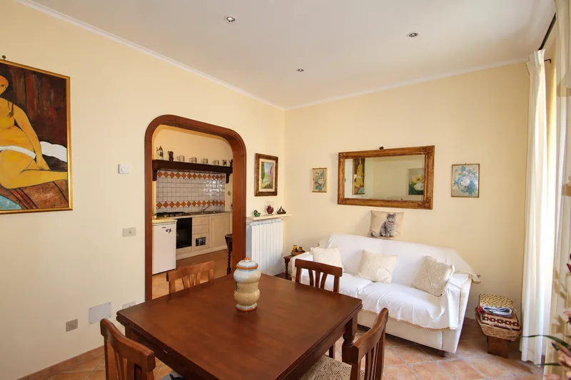 Soggiorno arredato con accesso alla cucina